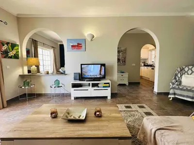 a living room with a flat screen tv and a living room with a couch at Casa Buccaneer, 2 Bedroom Garden Apartment in Praia da Luz in Luz