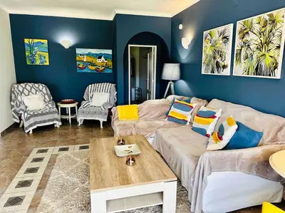 a living room with a couch and a table at Casa Buccaneer, 2 Bedroom Garden Apartment in Praia da Luz in Luz