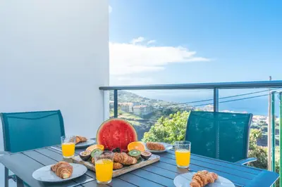 a table with a tray of food and orange juice at Casa Teixeira by Atlantic Holiday in Venda do Atalhinho