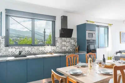 a kitchen and dining room with a table and a window at Casa Teixeira by Atlantic Holiday in Venda do Atalhinho