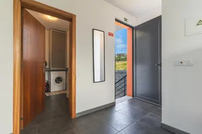 a hallway with a door leading to a washing machine at Casa Teixeira by Atlantic Holiday in Venda do Atalhinho