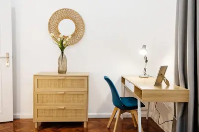 a desk with a vase of flowers and a mirror at GuestReady - Blissful Getaway in Funchal in Funchal