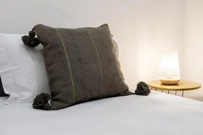 a pillow sitting on top of a bed next to a lamp at GuestReady - Blissful Getaway in Funchal in Funchal