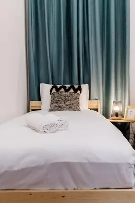 a bedroom with a white bed with a blue curtain at GuestReady - Blissful Getaway in Funchal in Funchal
