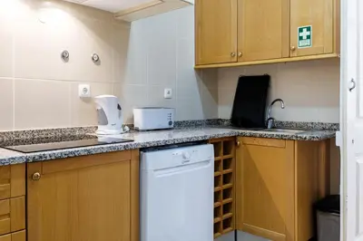 a kitchen with wooden cabinets and a white appliance on the counter at GuestReady - Blissful Getaway in Funchal in Funchal