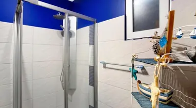 a bathroom with a shower with a glass door at O farol do funchal in Funchal