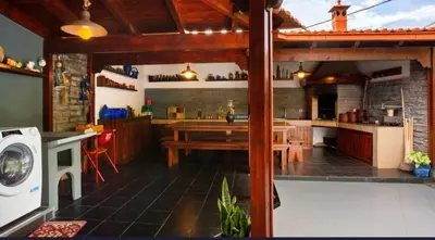 a large kitchen with a table and a stove at O farol do funchal in Funchal