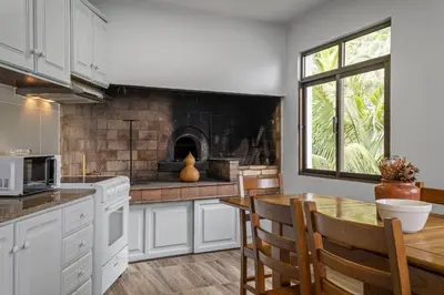 a kitchen with a table and a fireplace at Northern Secret by Homie in Ponta Delgada