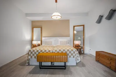 a bedroom with a large bed with a yellow stool at Northern Secret by Homie in Ponta Delgada