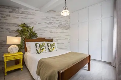a bedroom with a bed and a yellow end table at Northern Secret by Homie in Ponta Delgada