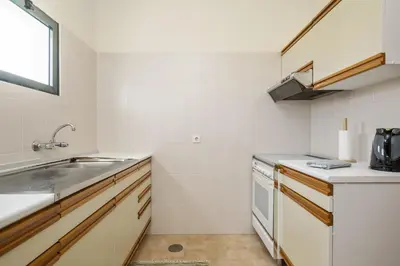 a small kitchen with a sink and a stove at Escapadinha do Sol by Homie in Porto Santo