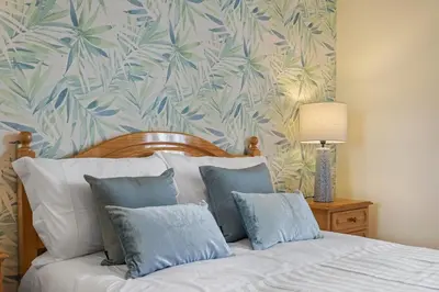 a bedroom with a bed with blue and white pillows at Escapadinha do Sol by Homie in Porto Santo
