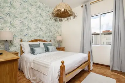 a bedroom with a bed and a large window at Escapadinha do Sol by Homie in Porto Santo