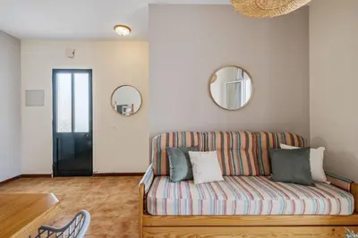 a living room with a couch and a mirror at Escapadinha do Sol by Homie in Porto Santo
