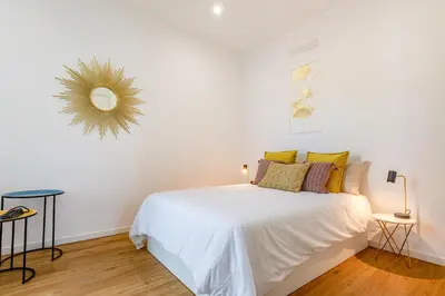 a white bedroom with a white bed and a mirror at Villa Mármore in Funchal