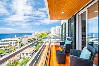 a balcony with chairs and a view of the ocean at Lido Sunrise Apartment by Homie in Funchal