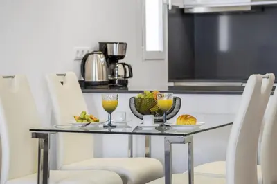 a table with a bowl of fruit and two glasses of juice at Lido Sunrise Apartment by Homie in Funchal