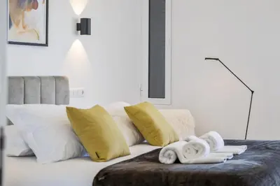 a bedroom with a bed with yellow and white pillows at Lido Sunrise Apartment by Homie in Funchal