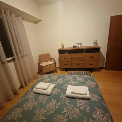 a bedroom with a bed and a dresser with two towels at Ina's Garden in Santa Cruz in Santa Cruz