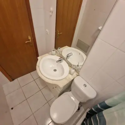 a bathroom with a white toilet and a sink at Ina's Garden in Santa Cruz in Santa Cruz