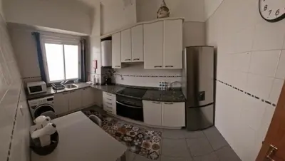 a kitchen with white cabinets and a stainless steel refrigerator at Ina's Garden in Santa Cruz in Santa Cruz