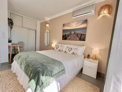 a bedroom with a bed and a painting on the wall at Oásis de verão- 2 bedrooms flat with swimming pool in Sagres