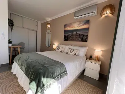 a bedroom with a bed and a painting on the wall at Oásis de verão- 2 bedrooms flat with swimming pool in Sagres