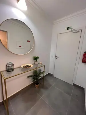 a bathroom with a mirror and a table and a door at Oásis de verão- 2 bedrooms flat with swimming pool in Sagres