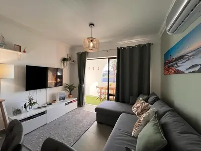 a living room with a couch and a tv at Oásis de verão- 2 bedrooms flat with swimming pool in Sagres