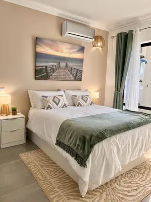 a bedroom with a bed with a painting on the wall at Oásis de verão- 2 bedrooms flat with swimming pool in Sagres