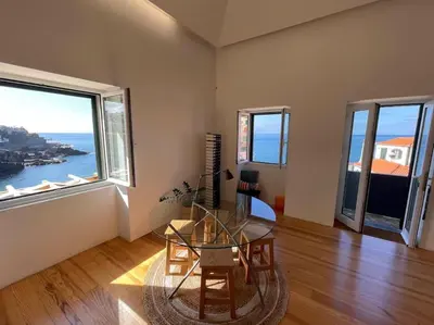 a large living room with white furniture and windows at Casa Mar Adentro in Câmara de Lobos