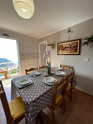 a dining room with a table with chairs and a tablecloth on it at Tropical House in Ribeira Brava