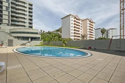 a swimming pool in the middle of a building at Blue and Gold Sunset by Homie in Funchal