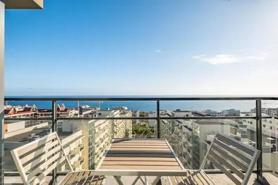 a balcony with two chairs and a view of the ocean at Blue and Gold Sunset by Homie in Funchal