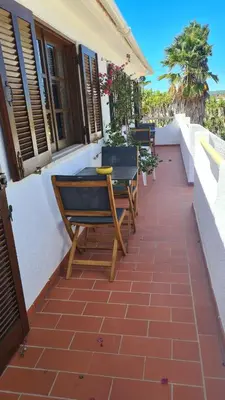 a patio with chairs and a table on a building at RÉSIDENCE LES ARCADES in Almádena