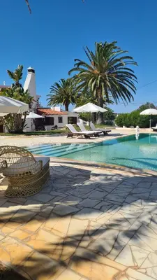 a swimming pool with chairs and umbrellas in a resort at RÉSIDENCE LES ARCADES in Almádena