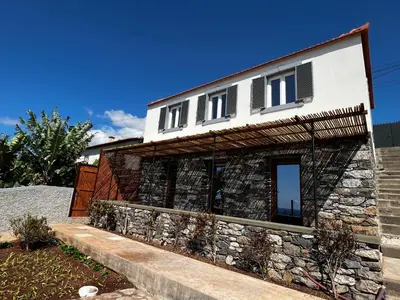 a house with a stone wall at CASAS DO LARANJO- Cottages & Infinity Pool in Gaula