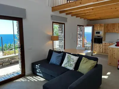 a living room with a couch and a table and a kitchen at CASAS DO LARANJO- Cottages & Infinity Pool in Gaula