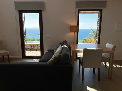 a living room with a couch and a table with a view at CASAS DO LARANJO- Cottages & Infinity Pool in Gaula
