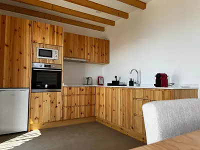 a kitchen with wooden cabinets and a white appliance at CASAS DO LARANJO- Cottages & Infinity Pool in Gaula