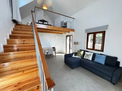 a living room with a blue couch and a staircase at CASAS DO LARANJO- Cottages & Infinity Pool in Gaula