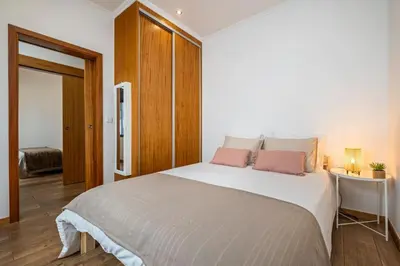 a bedroom with a large white bed with two pink pillows at Casa do Pina in Funchal