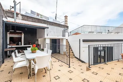 a balcony with a white table and white chairs at Casa do Pina in Funchal