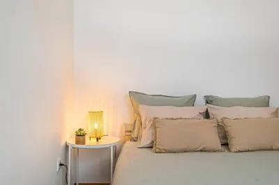 a bed with a table with a lamp on it at Casa do Pina in Funchal