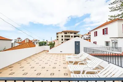 a balcony with white chairs on top of a building at Casa do Pina in Funchal