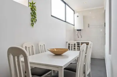 a white dining room with a white table and chairs at Casa do Pina in Funchal