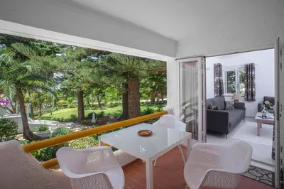 a swimming pool with lounge chairs and umbrellas at Garden T2 Apartment in Luz in Luz