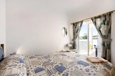 a bedroom with a bed and a window at Casa Do Poço in Budens