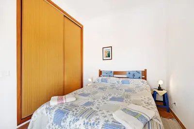 a bedroom with a large bed with a wooden headboard at Casa Do Poço in Budens