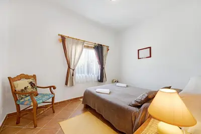 a bedroom with a large bed and a window at Casa Do Poço in Budens